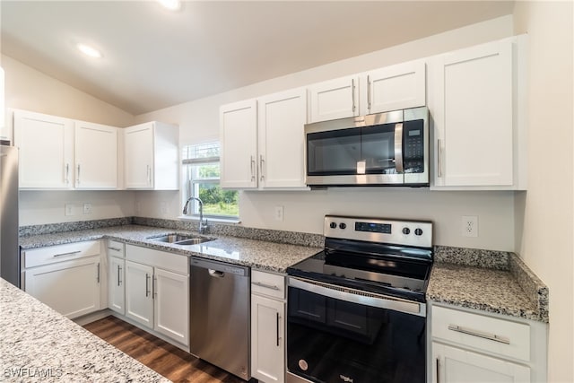 kitchen with stainless steel appliances, lofted ceiling, dark hardwood / wood-style flooring, white cabinets, and light stone countertops