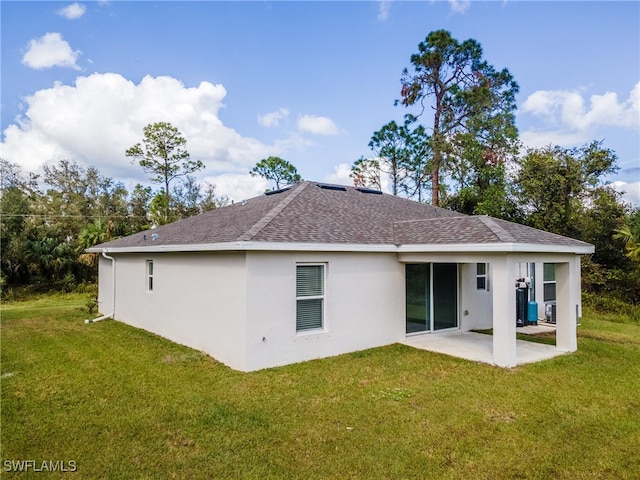 back of house featuring a patio and a yard