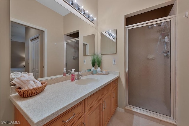 bathroom featuring tile patterned floors, vanity, and a shower with shower door