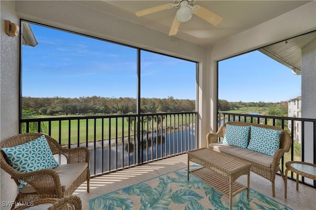 sunroom / solarium featuring a water view and ceiling fan