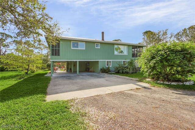 rear view of house with a carport and a yard