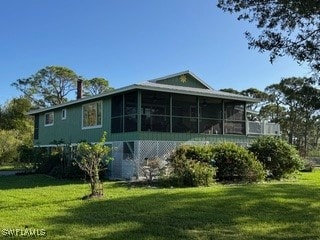 back of property featuring a yard and a sunroom