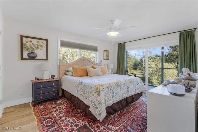 bedroom featuring ceiling fan, access to exterior, wood-type flooring, and multiple windows