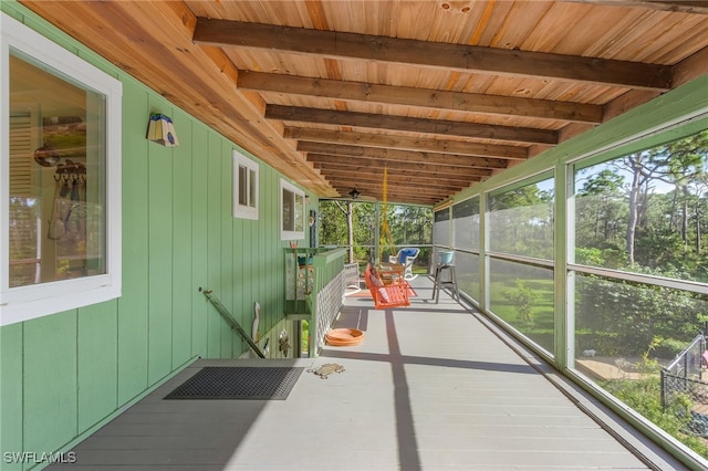 unfurnished sunroom featuring vaulted ceiling with beams and wooden ceiling