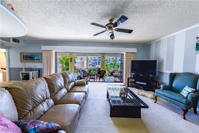 carpeted living room featuring ceiling fan, crown molding, and a textured ceiling