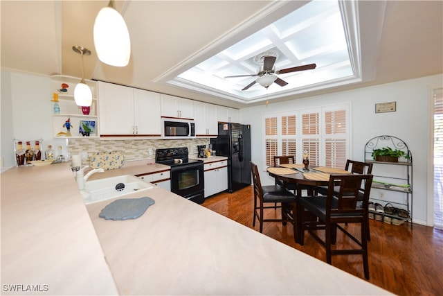 kitchen featuring a wealth of natural light, sink, black appliances, white cabinetry, and hanging light fixtures