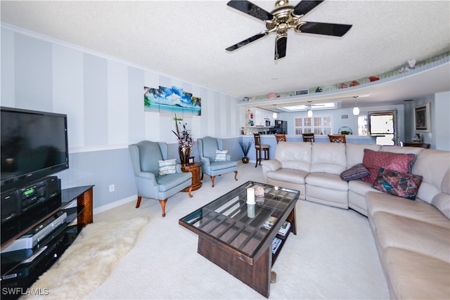 living room with light carpet, crown molding, and a textured ceiling