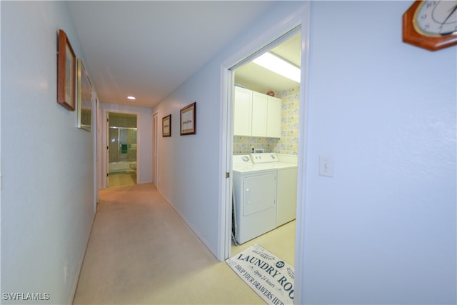 hall with washer and dryer and light carpet