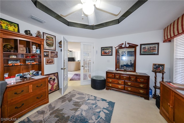 bedroom featuring ceiling fan, french doors, light colored carpet, and a textured ceiling