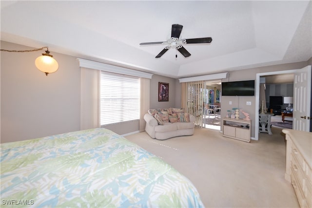 bedroom with ceiling fan, a raised ceiling, and light colored carpet