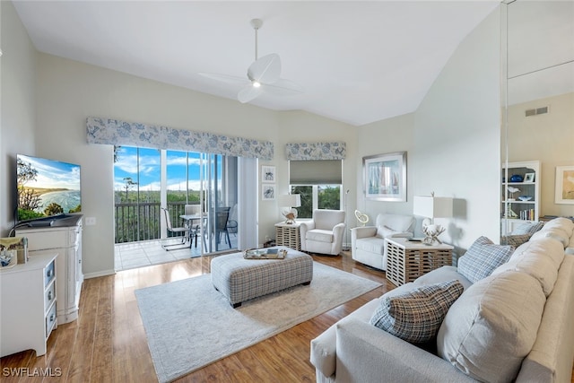 living room with light wood-type flooring, high vaulted ceiling, and ceiling fan