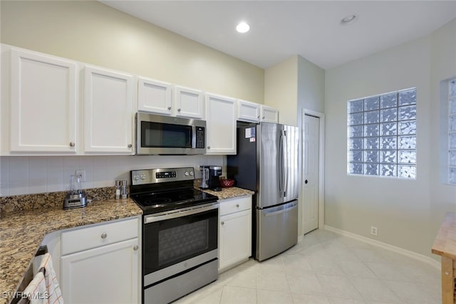 kitchen featuring stone counters, white cabinets, and stainless steel appliances