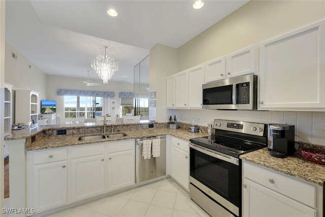 kitchen featuring white cabinetry, sink, stainless steel appliances, kitchen peninsula, and a chandelier