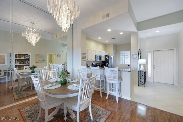 dining area featuring a notable chandelier and light wood-type flooring