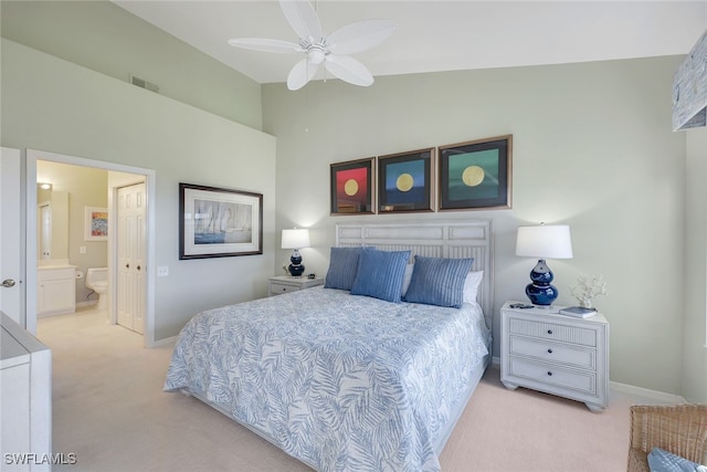 bedroom with light carpet, ensuite bathroom, ceiling fan, and lofted ceiling