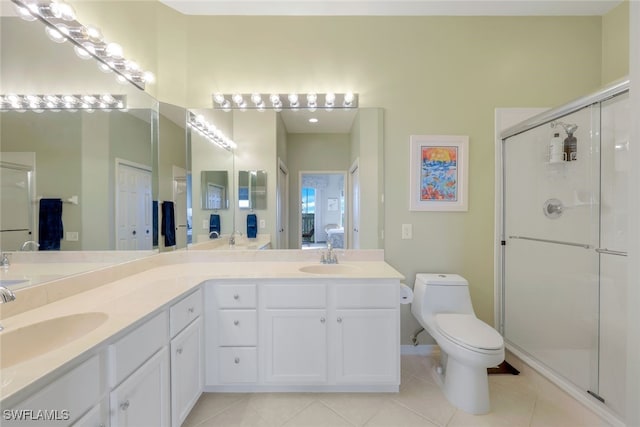 bathroom with tile patterned floors, a shower with door, vanity, and toilet