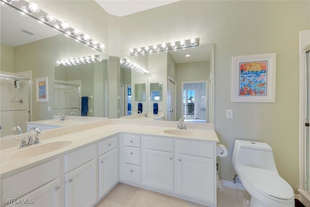 bathroom with vanity, toilet, a shower with shower door, and tile patterned flooring