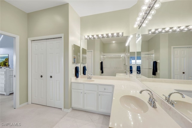 bathroom featuring tile patterned flooring, vanity, and walk in shower