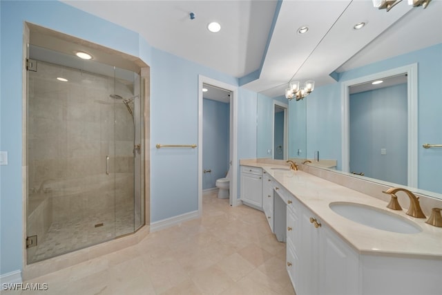 bathroom with vanity, toilet, a shower with shower door, and a notable chandelier