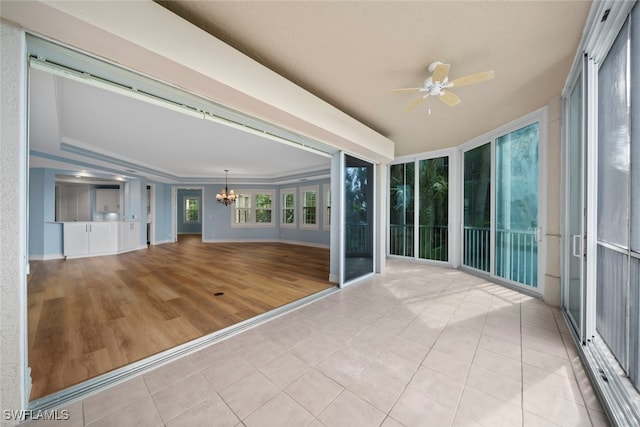 unfurnished sunroom with lofted ceiling and ceiling fan with notable chandelier