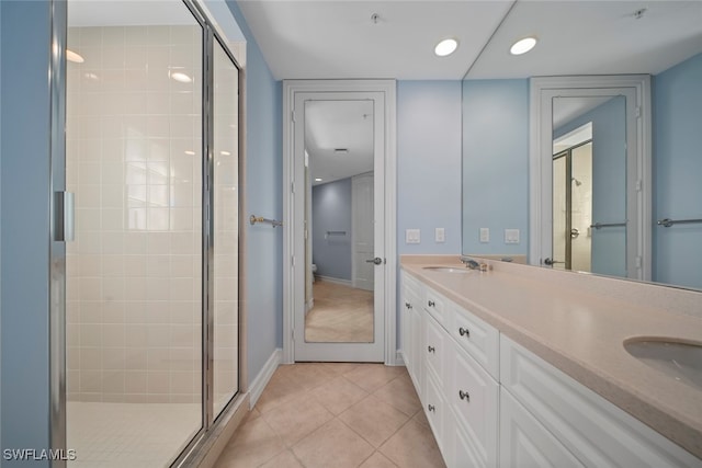 bathroom with tile patterned floors, a shower with door, and vanity