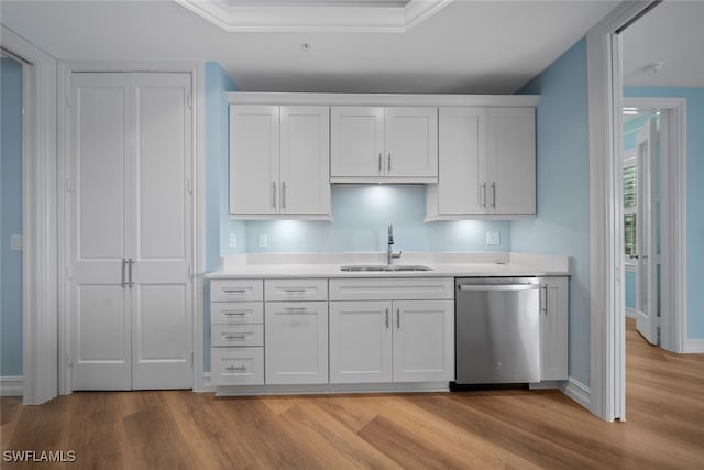 kitchen with stainless steel dishwasher, ornamental molding, sink, white cabinets, and light hardwood / wood-style floors