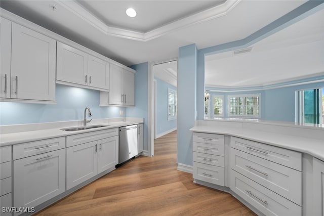 kitchen featuring a raised ceiling, dishwasher, light hardwood / wood-style floors, and sink