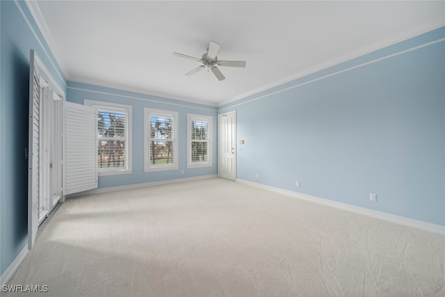 carpeted spare room featuring ceiling fan and ornamental molding