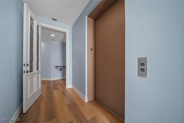 hall featuring light wood-type flooring and elevator