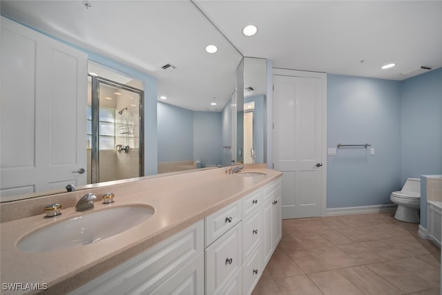 bathroom featuring tile patterned flooring, vanity, toilet, and an enclosed shower