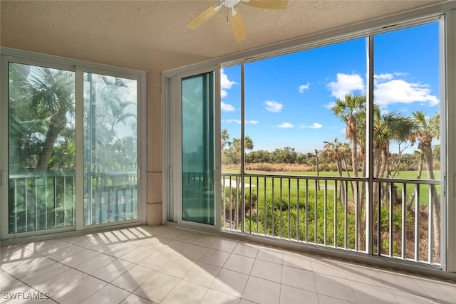 unfurnished sunroom with ceiling fan and a wealth of natural light