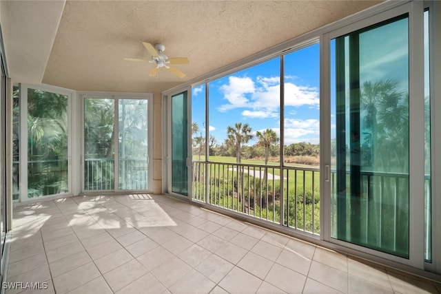 unfurnished sunroom featuring a wealth of natural light and ceiling fan