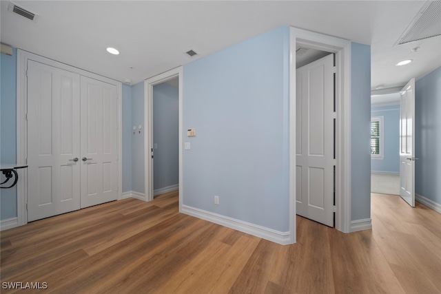 unfurnished bedroom featuring a closet and hardwood / wood-style flooring