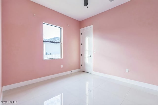 empty room with tile patterned floors and ceiling fan