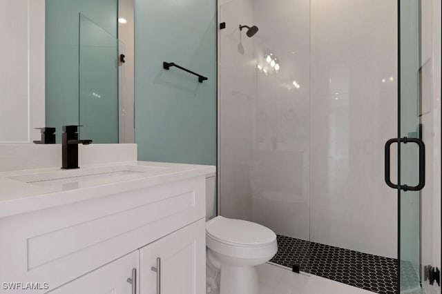 bathroom with vanity, toilet, and a shower with shower door