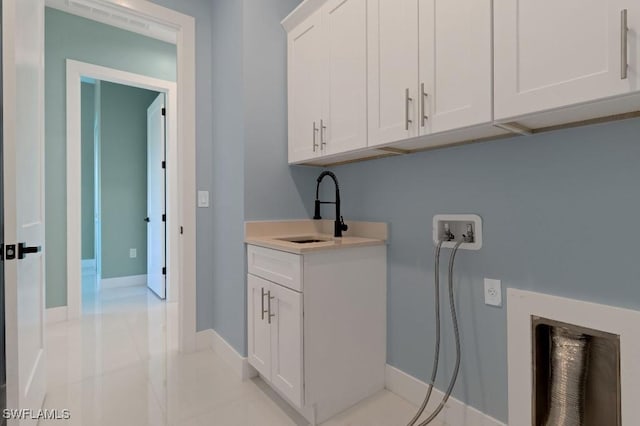 laundry room featuring cabinets, hookup for a washing machine, light tile patterned flooring, and sink