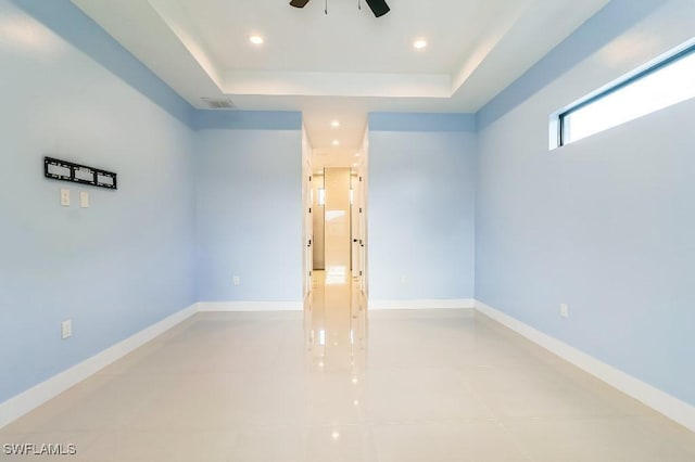 unfurnished room with a tray ceiling and ceiling fan