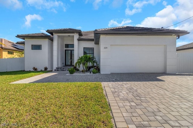 view of front of property with a garage and a front lawn