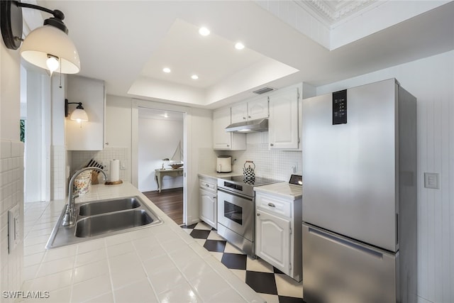 kitchen with appliances with stainless steel finishes, backsplash, white cabinetry, and sink