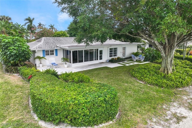 rear view of property with a lawn and a patio