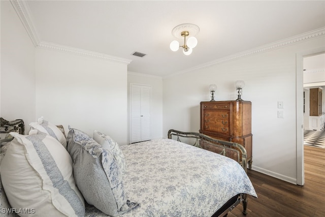 bedroom with dark hardwood / wood-style flooring, a closet, and crown molding