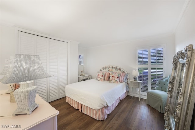 bedroom featuring dark hardwood / wood-style floors, crown molding, and a closet