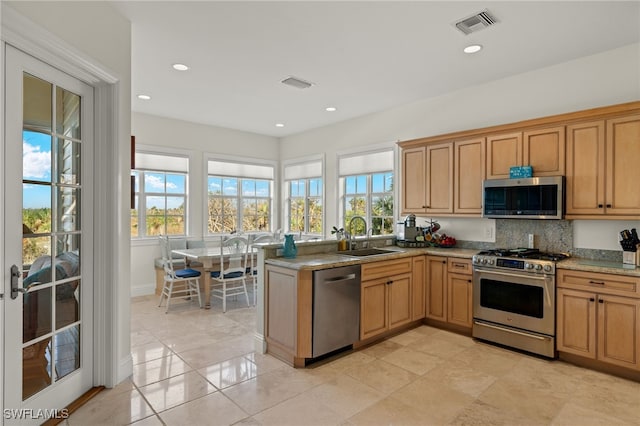 kitchen with stainless steel appliances, sink, kitchen peninsula, tasteful backsplash, and light tile patterned floors