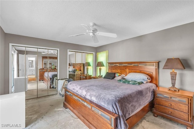 bedroom featuring ceiling fan, a textured ceiling, and multiple closets