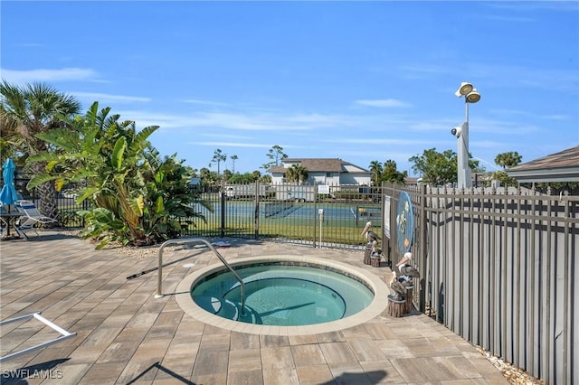 view of pool with an in ground hot tub and a water view