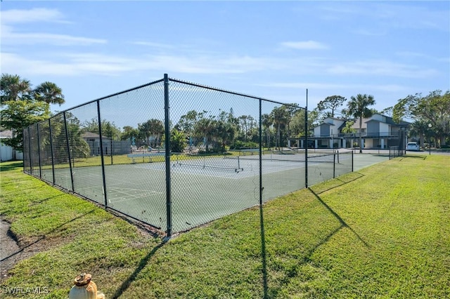 view of tennis court featuring a yard