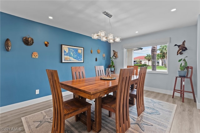 dining room with a chandelier and light wood-type flooring