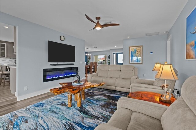 living room with ceiling fan and dark hardwood / wood-style floors