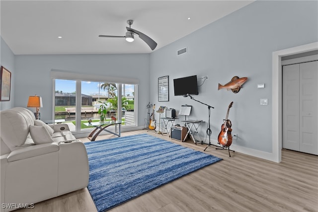 living room featuring ceiling fan, high vaulted ceiling, and light hardwood / wood-style flooring