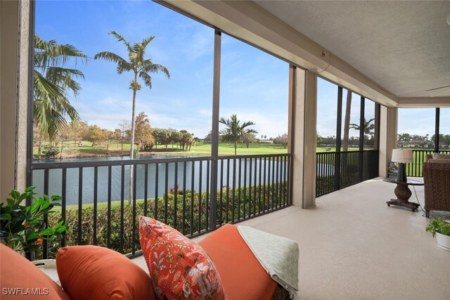 sunroom featuring a water view